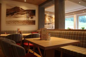 une salle à manger avec des tables et des chaises dans un restaurant dans l'établissement Hotel Garni Lärchenhof, à Lech am Arlberg