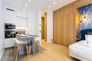 a kitchen and living room with a bed and a kitchen counter at Cosy & Luxury Kléber Trocadéro Arc de Triomphe in Paris