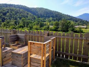 a wooden deck with a fence and mountains in the background at Garden ECO houses Čebelica in Bohinj