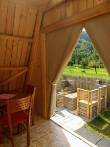 een uitzicht vanaf de binnenkant van een tent met een tafel en stoelen bij Garden ECO houses Čebelica in Bohinj