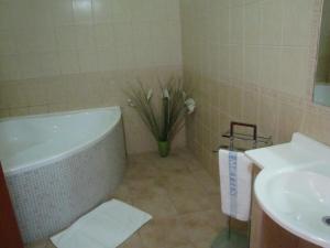 a bathroom with a bath tub and a sink at Hotel Hubert Nové Zámky in Nové Zámky
