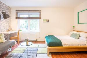 Un dormitorio con una cama, un sofá y una mesa. en Tower Bridge Rainbow Suites, en Londres