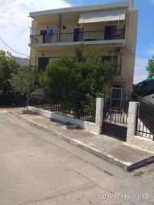 a building with a fence in front of it at KROKOS HOUSE in Aliveri