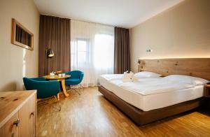 ein Hotelzimmer mit einem Bett, einem Tisch und Stühlen in der Unterkunft Rogner Bad Blumau in Bad Blumau