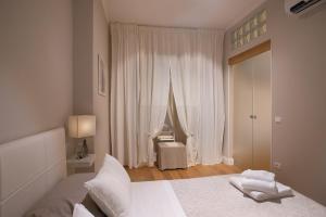 a white bedroom with a bed and a large window at Didi House in Florence