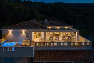 een huis met een terras en een zwembad in de nacht bij Secret Escape Penthouse in Slatine +27 foto's