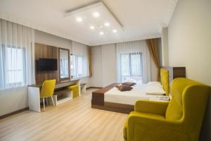 a bedroom with a bed and a desk and a chair at ÇAYKARA PARK HOTEL in Çaykara