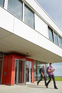 two men walking in front of a building at Youth Hostel Beaufort in Beaufort