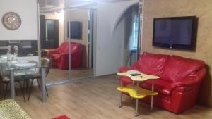 a living room with a red couch and a table at Студия in Kryvyi Rih