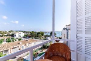 einen Balkon mit Rattanstuhl und Stadtblick in der Unterkunft Hostal Residencia San Francisco in Portocolom