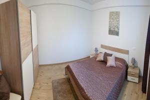 - une chambre avec un lit et des oreillers roses dans l'établissement APARTMENT NORINA, à Grožnjan