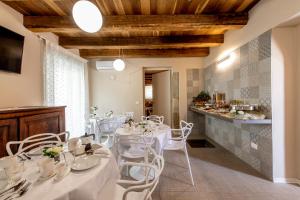 een eetkamer met witte tafels en witte stoelen bij RESIDENZA DON ALBERTO in Ornano Grande