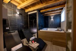 a bathroom with two chairs and a bath tub at RESIDENZA DON ALBERTO in Ornano Grande