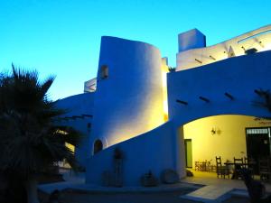 un edificio blanco con una palmera delante en Agriturismo Tenuta Del Morige, en Galatone