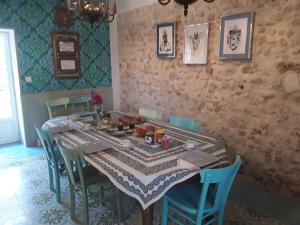 a dining room with a table and blue chairs at 'La Ménagerie' in Châteauvieux