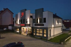 a large white building with a sign on it at Hotelik 51 in Pasłęk