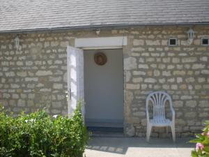 una sedia bianca seduta davanti a una porta di Domaine Saint-Hilaire a Saint-Hilaire-Petitville