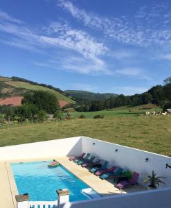 a view of a swimming pool with lounge chairs at Maison Zubiatia - 3km Compostelle in Saint-Jean-le-Vieux