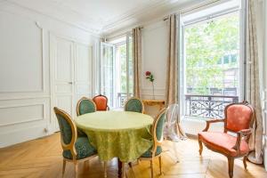 a dining room with a table and chairs and a window at Veeve - By Boulevard Saint Germain in Paris