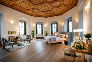 a large bedroom with a bed and a living room at JUFA Hotel Schloss Röthelstein in Admont +48 photos