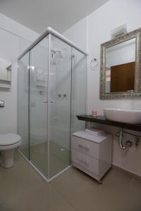 a bathroom with a glass shower and a sink at Hospedagem da Escultora in Treze Tílias