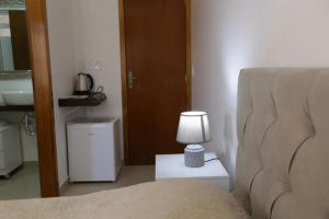 a bedroom with a bed and a lamp on a table at Hospedagem da Escultora in Treze Tílias