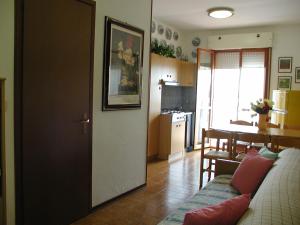 a living room with a couch and a kitchen at Appartamenti Valbella con piscina in Bibione