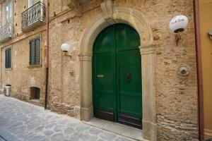 zielone drzwi na boku budynku w obiekcie Residenza Vecchi Tempi w mieście Vibo Valentia