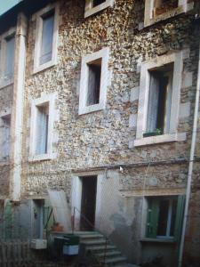 an old stone building with windows and a staircase at F1 duplex Bleuet Rénové in Lamalou-les-Bains