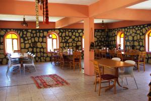 a dining room with tables and chairs and windows at Nemrut Kervansaray Hotel in Karadut