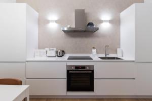 eine weiße Küche mit einer Spüle und einem Herd in der Unterkunft Italianway - Vigevano 13 in Mailand