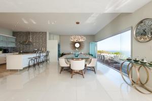 uma cozinha e sala de jantar com mesa e cadeiras em Leisure and Golf Retreat Villa Pinnacle Point em Mossel Bay