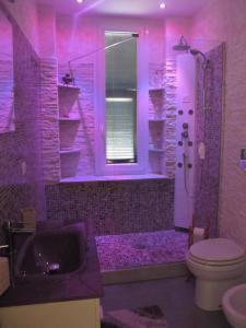 Baño púrpura con aseo y lavamanos en LA GEMMA en Génova