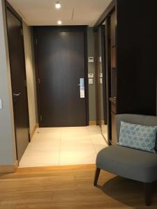 un pasillo con una silla y una puerta negra en Puerto Norte Design Hotel en Rosario