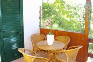 Villaggio Club Baia di Paradiso في بيسكيتشي: طاولة وكراسي على شرفة مع إناء عليها