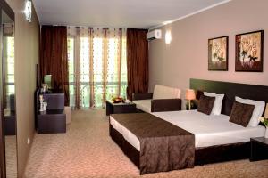 a hotel room with a bed and a couch at Central Plaza in Pomorie