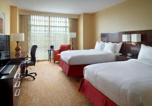 a hotel room with two beds and a desk at Marriott Bloomington Normal Hotel and Conference Center in Bloomington