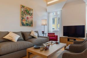 a living room with a couch and a tv at Trendy & Classic 2bedroom apartment in Lisbon