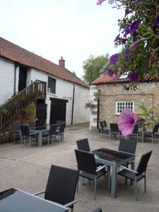 a patio with chairs and tables in front of a building at The New Inn in Thornton Dale