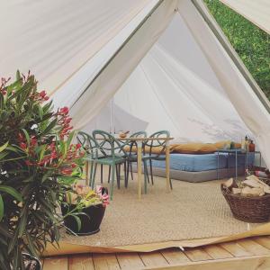 a tent with a table and chairs and plants at Silver Trees - Glamping in Fresse-sur-Moselle