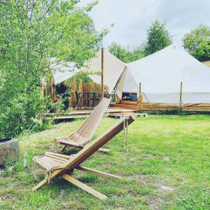 a couple of lounge chairs in a field with tents at Silver Trees - Glamping in Fresse-sur-Moselle