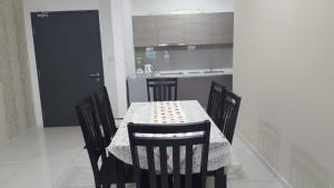 a dining room table with chairs and a kitchen at DREAM HOME @ Emira Residence, Section 13 Shah Alam in Shah Alam