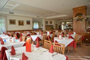 a dining room with tables and chairs with red napkins at Hotel Bel Sit in Comano Terme