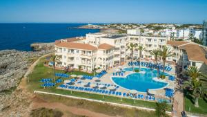 an aerial view of a resort with a swimming pool at Grupotel Tamariscos in Cala en Bosc