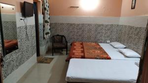 a hotel room with two beds and a tv at Vidya Guest House in Katra