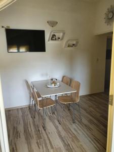 een eettafel met stoelen en een tv aan de muur bij Apartment Josipa in Grebaštica