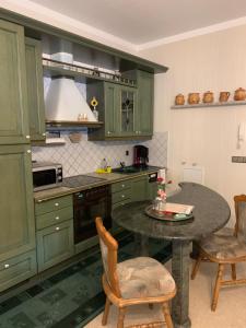 uma cozinha com armários verdes e uma mesa com cadeiras em Ferienwohnung Anke Huhn em Nordhausen