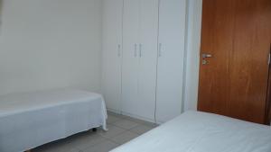 1 dormitorio con 2 camas y puerta de madera en Golden Flat, en João Pessoa