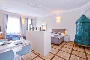 a living room with a bed and a table and chairs at Stylische Cityapartments Benedikt in Klagenfurt