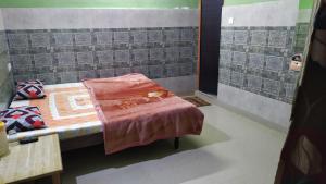 a small room with a bed and a table at Vidya Guest House in Katra